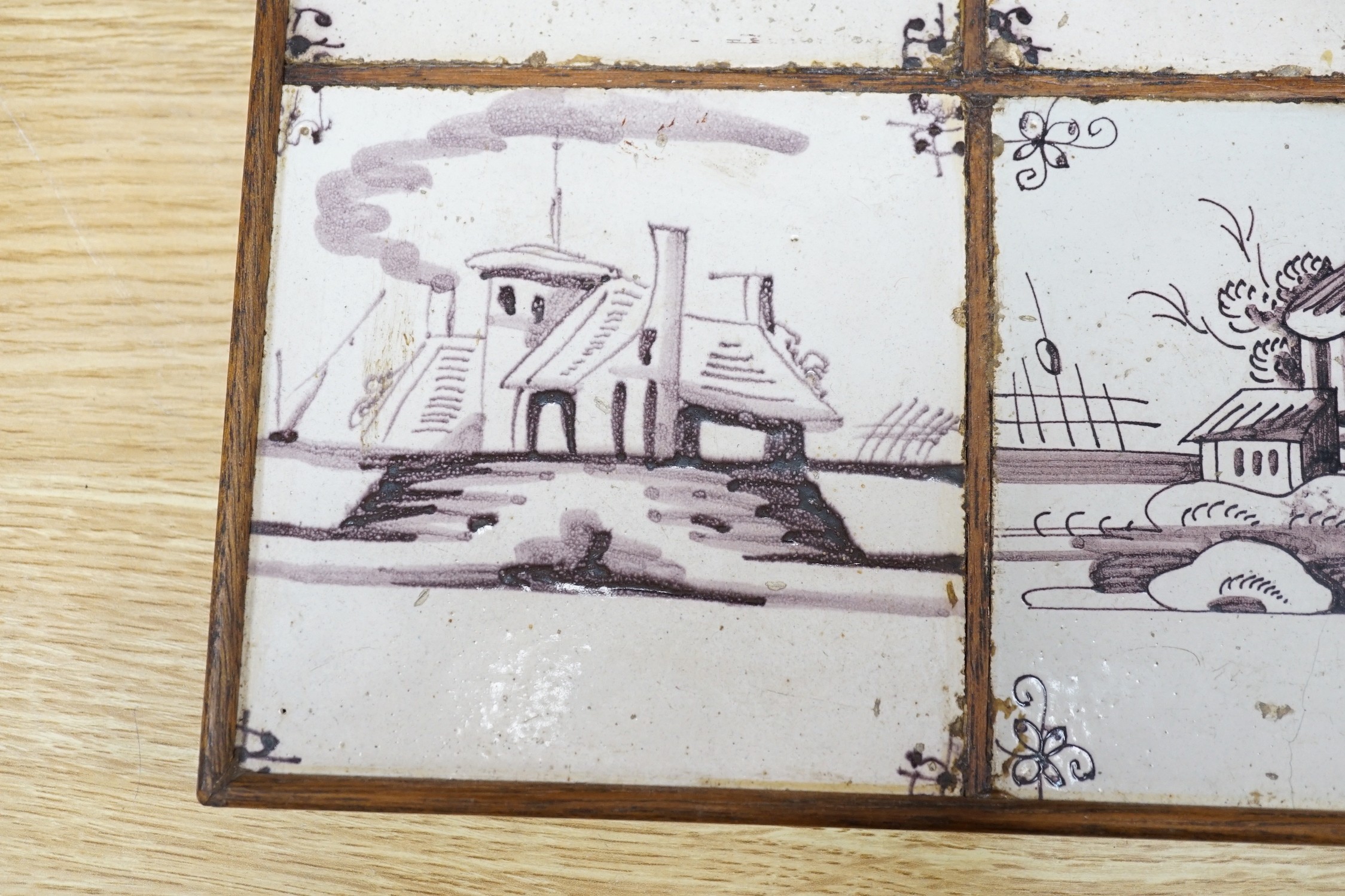 A set of four 18th century Dutch Delft manganese tiles decorated with buildings by a canal (frame 27cm)